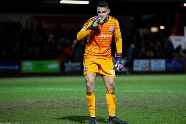 Accrington keeper Dimitar Evtimov jokingly pretends to drink from the cup prior to his sending off