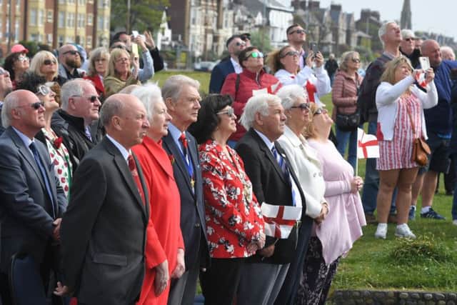 Civic officials and members of the public look on as the flag is raised at Lytham Green