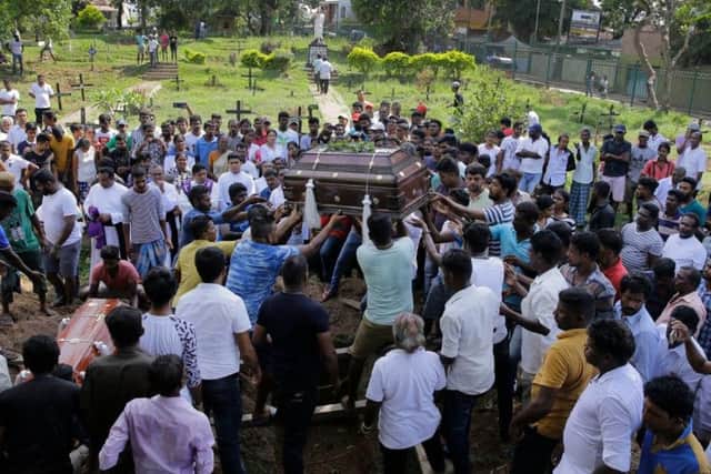 Sri Lankans prepare to bury the coffins carrying remains of Berington Joseph and Burlington Bevon, who were killed in the Easter Sunday bombings in Colombo