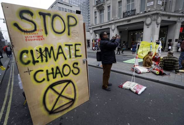 Writing on the side of a temporary toilet set up as the road is blocked during a climate protest at Oxford Circus in London, Tuesday, April 16, 2019. The group Extinction Rebellion is organizing a week of civil disobedience against what it says is the failure to tackle the causes of climate change. (AP Photo/Kirsty Wigglesworth)