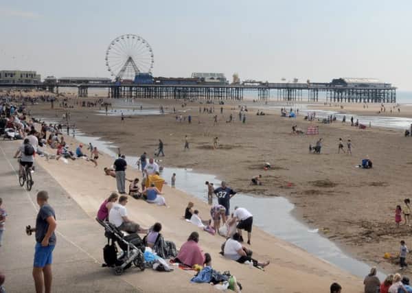 Visitors on Blackpool beach and promenade
