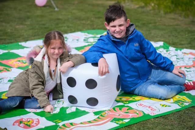 Kelsey Mai Dooner and Joshua Shaw McGhee playing giant snakes and ladders.l