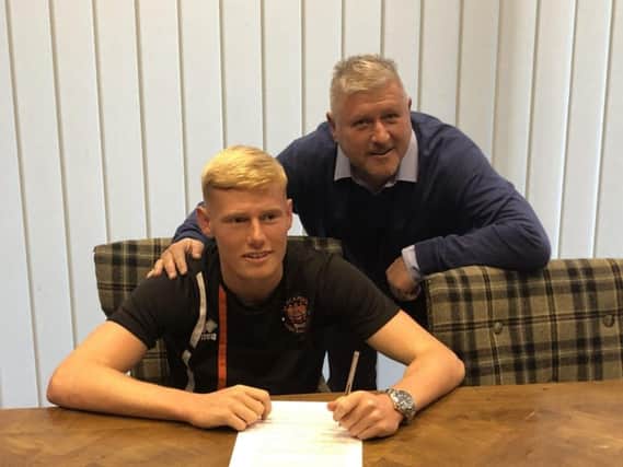 Blackpool boss  Terry McPhillips watches Oliver Watkinson sign his first professional contract