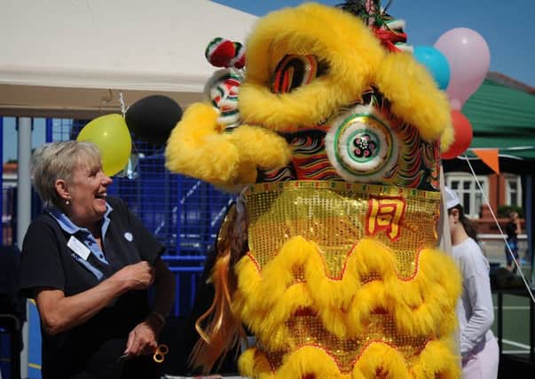 Community fun day in Highfield Park, South Shore.
The Chinese lion dancer decides to join the Guides.  PIC BY ROB LOCK
24-6-2018