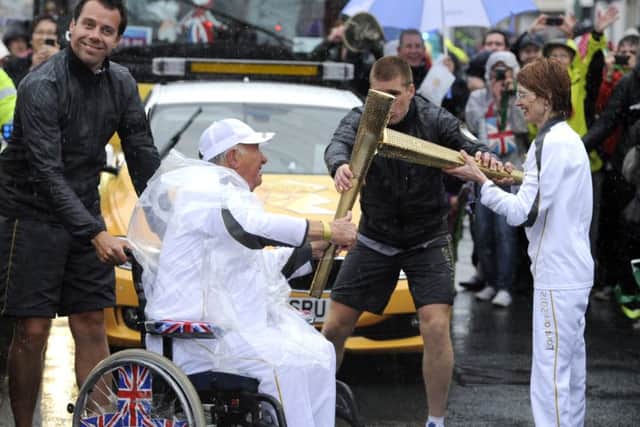 Torchbearer 110 Heather Harper passes the Olympic Flame to Torchbearer 111 David Burns on the Torch Relay leg between Fleetwood and Blackpool. The Torchbearer's name is provided in good faith, however the Press Association has been unable to verify it independently.