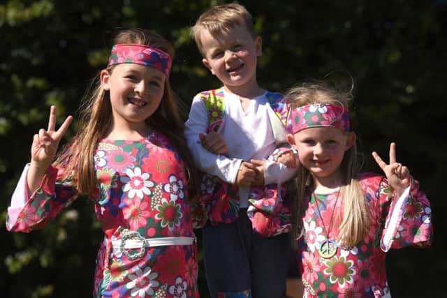 Pupils, parents and staff take part in BreckFest at Breck Primary School to celebrate 50 years, singing songs from 1968 and dressing in sixties clothes.  Pictured are Isobelle, Charlie and Ava Downham.