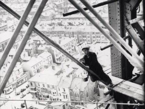 Undated picture of a man working precariously at the top of the Tower