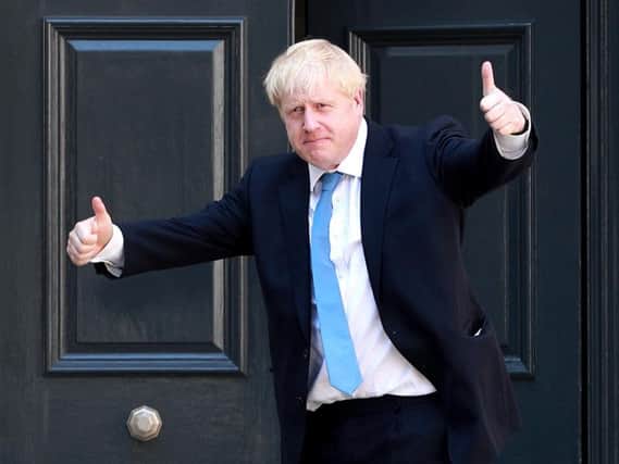 Newly elected Conservative party leader Boris Johnson poses outside the Conservative Leadership Headquarters