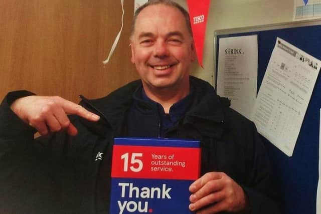 Staining dad Shaun Winstanley with his 15-year service award from Tesco