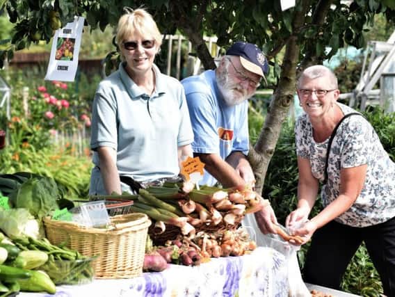 Val Woodcock and Peter Stead serve some vegetables grown on the allotments to Anna Pawson
