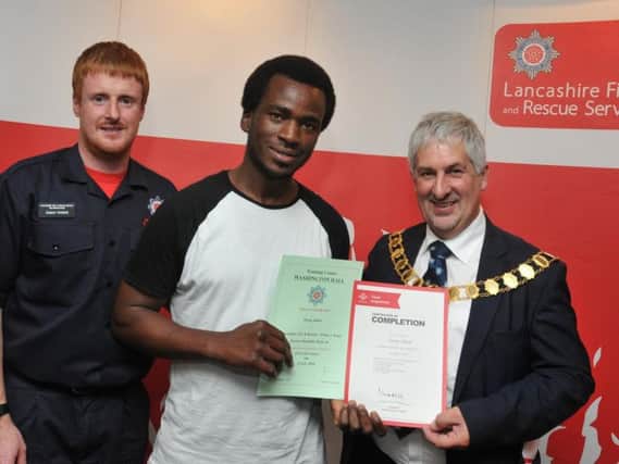 Adam Hollett from Lancashire Fire and Rescue Service, left, and Mayor of Preston Coun Trevor Hart, right, presents Tarag, centre, with his certificate in 2018.