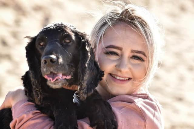 This owner gives her pet pooch an encouraging cuddle during the beach walk