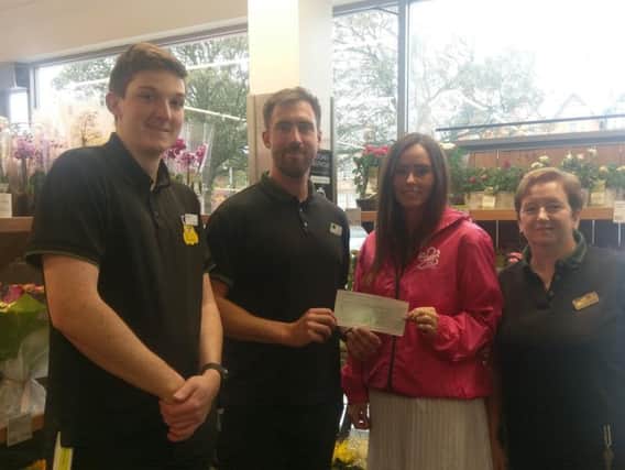 Staff from Marks & Spencer present a cheque to Alzheimers Society fund-raising volunteer Kelly Smith.