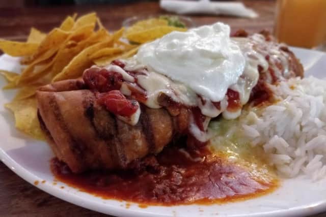 The chimichanga: a large flour tortilla filled with chilli beef, deep fried and served with rice, cheese, salsa, sour cream, guacamole and although it wasnt mentioned on the menu some tortilla chips (12.45)