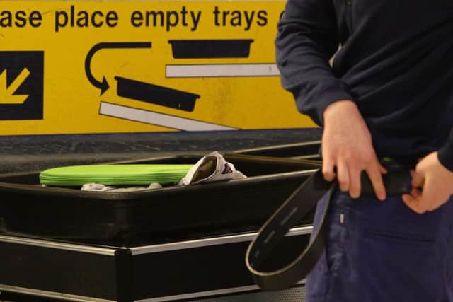A passenger replacing a belt after having passed through security at Manchester Airports Terminal 1