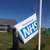 Knott End chairman David Weir raises the NHS flag outside the club