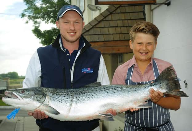 The Cartford Inn in Little Eccleston has just taken delivery of one of the largest salmon ever caught in the River Ribble near Lytham. James Hayton from Midland Fish Company and 13 year-old Teo Beaume get to grips with the giant fish, which was caught by Billy McKean.  PIC BY ROB LOCK 2-8-2013