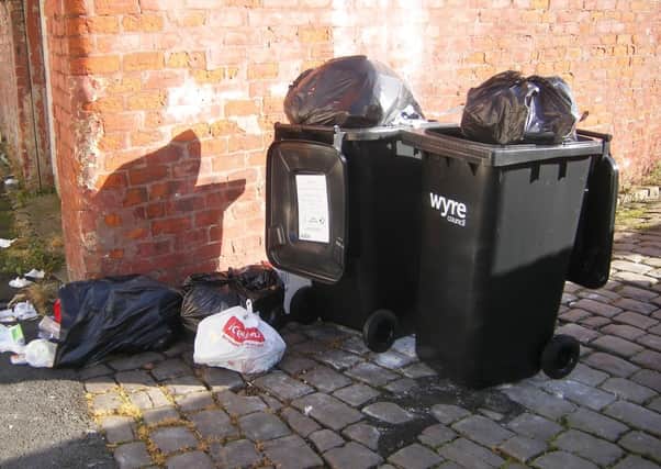 Overloaded wheelie bins in an alleyway in Fleetwood.