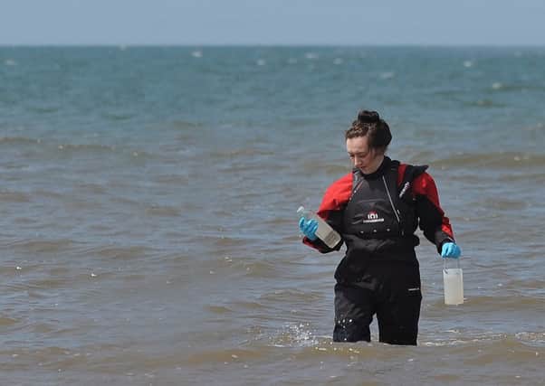 An Environment Agency employee takes water samples off Blackpool beach.