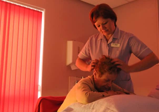 Donna Clarke gives a therapy treatment at Trinity Hospice