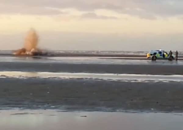 Royal Navy bomb squad detonate a suspected WWII bomb (below) on the beach.