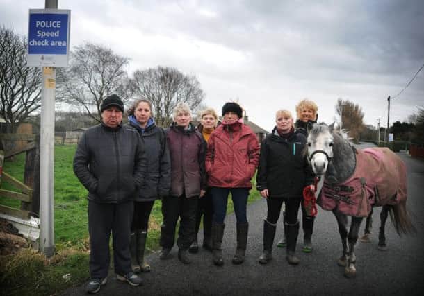 Residents and horse riders on Midgeland Road and Division Lane in the Marton Moss area of Blackpool are furious that road closures have meant a huge increase in traffic down their narrow lanes and claim that it is only a matter of time before a serious accident occurs.
Residents (including spokeswoman Anne Sergeant third left) on Midgeland Road next to a police sign.  PIC BY ROB LOCK
5-2-2014