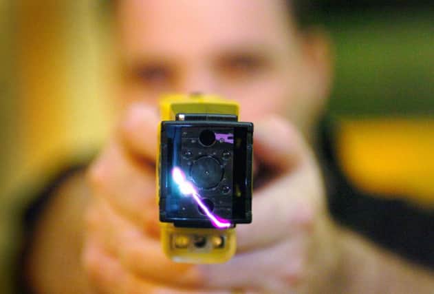 File photo dated 31/10/05 of a Police officer demonstrating a Taser gun. PRESS ASSOCIATION Photo. Issue date: Monday November 24, 2008. Police are to be armed with 10,000 Taser stun guns as part of a drive to tackle violent crime. Home Secretary Jacqui Smith is expected to announce plans to train front-line response officers in all 43 police forces in England and Wales to fire Tasers at violent suspects.