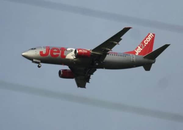 Jet2 aeroplane pictured through electricity wires landing at Blackpool Airport.