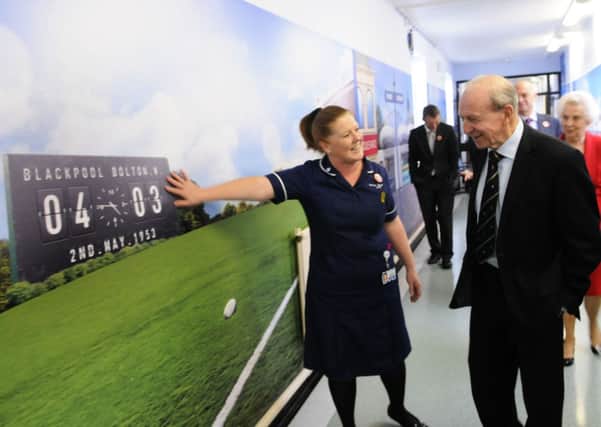 Jimmy Armfield opens the new Memory Corridor at Blackpool Victoria Hospital.  He is given a tour by practice development sister Sam Woodhouse.