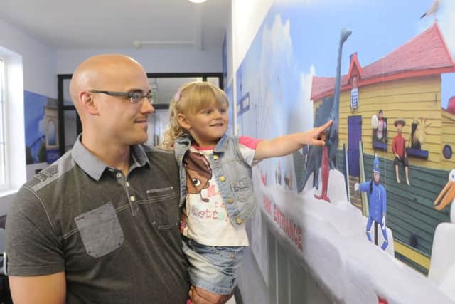Jimmy Armfield opens the new Memory Corridor at Blackpool Victoria Hospital.  Ben Walmsley who helped paint the corridor with daughter Gracie-Mae Walmsley, aged 2.