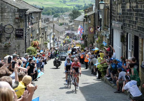The break away group rides up Main Street as stage two of the Tour de France passes through Haworth, Yorkshire