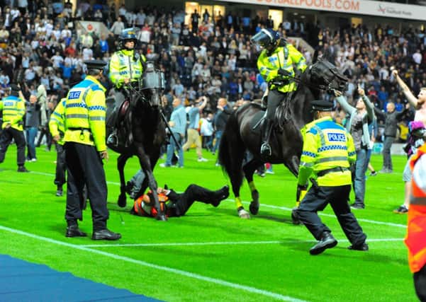 Hoof it: Deepdale steward Alan Entwistle is trampled underfoot during a derby day pitch invasion