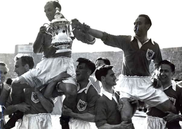 Historic moment: Stanley Matthews carried alongside Harry Johnston. Below - his winners medal