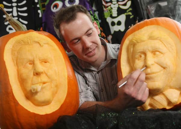 Spoook-tacular derby: Simon McMinnis putting the finishing touches to pumpkin likenesses of Louis Van Gaal and Manuel Pellegrini