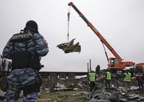 Recovery workers in rebel-controlled eastern Ukraine load debris from the crash site of Malaysia Airlines Flight 17, in Hrabove, Ukraine