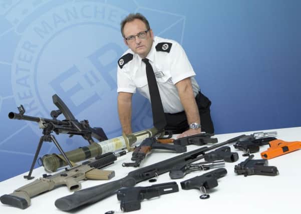 Assistant Chief Constable Ian Wiggett with previously 
confiscated firearms