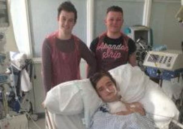Thumbs up: 18-year-old heart transplant patient Joe Higgins, from Poulton, is visited in hospital by best friends Henry Atherton and Tony Thompson