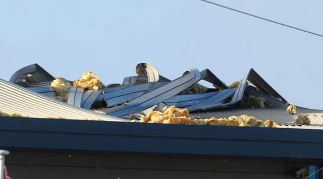 Broken landmark: Gale-force winds have ripped off a section of the tram depot at the bottom of Squires Gate Lane in Blackpool, scattering insulating material over a wide area.