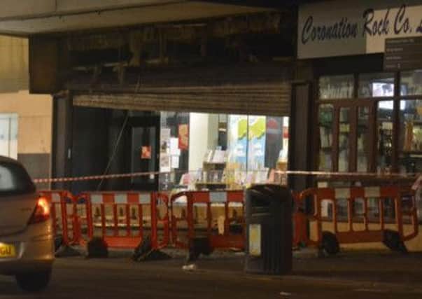 Tragic scene: A police cordon around the fallen sign outside the Bank Hey Street store last night