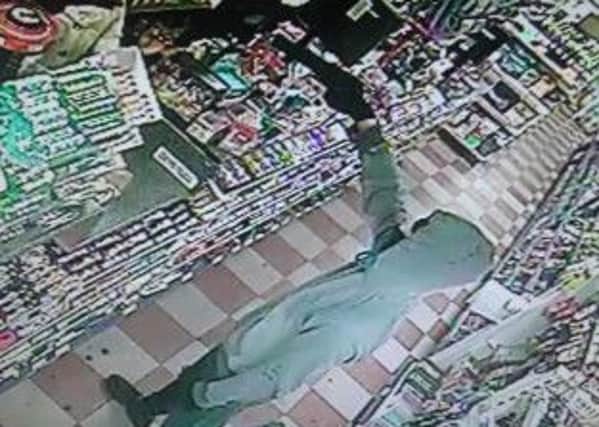 This is the moment the gun was pointed at a shopkeeper and his family.