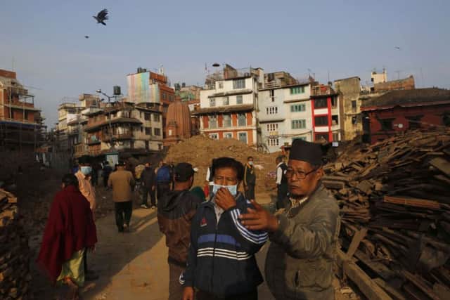 Nepalese men look at buildings damaged in an earthquake at the Durbar Square in Kathmandu, Nepal. Photo: AP Photo/Manish Swarup