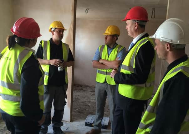 Clive Grunshaw (far right) talks to workers from social enterprise Jobs, Friends and Houses