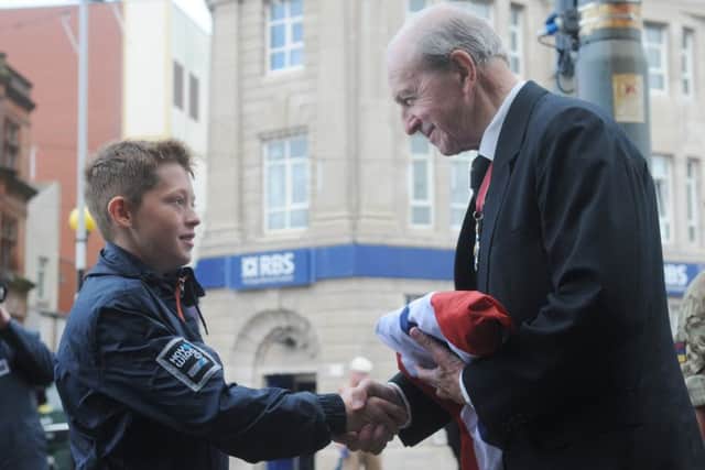 Flag raising ceremony to mark the start of Armed Forces Week in Blackpool.  Weeton Primary School pupil Daniel Fryer passes the flag to Jimmy Armfield.