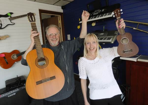 John Shaw and Julie Jackson from Blackpool Music Academy celebrate the arrival of donated instruments
