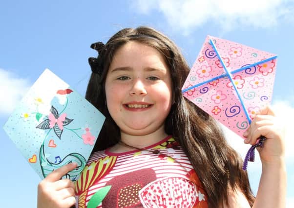 Nine-year-old Erin McKay with kites she prepared at the Let's Go Fly A Kite family crafts event at St Anne's Library