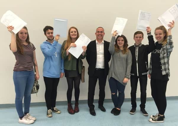 Fleetwood High School students celebrate their GCSE results with head teacher Richard Barnes (centre).