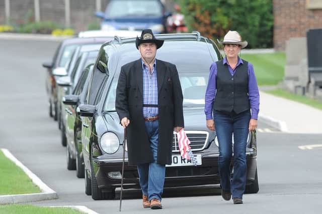Hearse being led by funeral directors