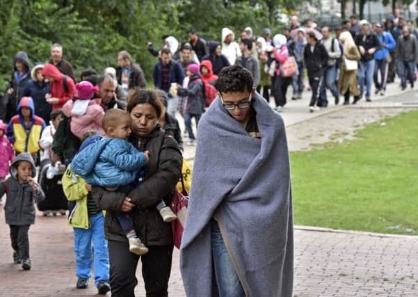 Plight: Refugees walk from the main station in Dortmund, Germany