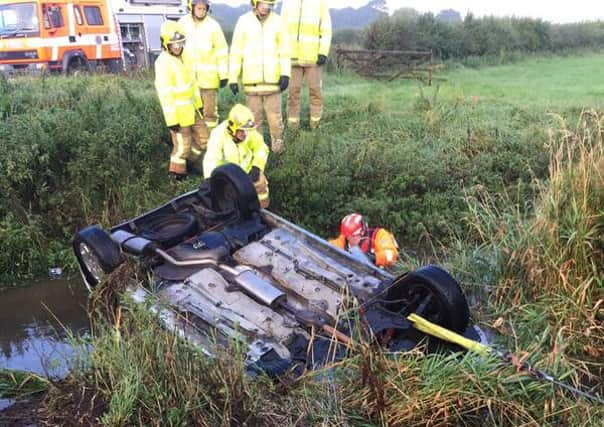 Fire officers at the scene of a overturned car in Warton. Picture: Paul Briggs, Lancs Fire and Rescue Service