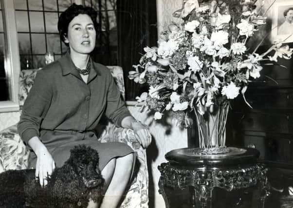 George Formby's fiancee Pat Howson with a birthday bouquet of flowers from the star and her pet poodle Bambi